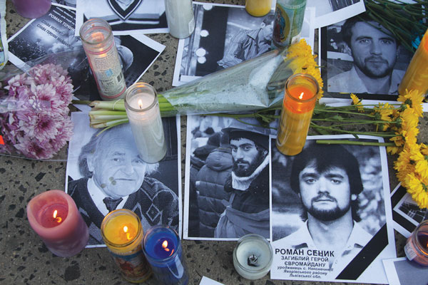 Some of the 40 to 50 photos of the fallen Euromaidan heroes at a memorial outside 136 Second Ave. on Sunday.  Photos by Tequila Minsky