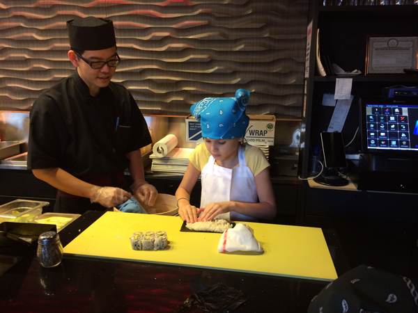  Chef Paul Tun helps little sushi chef student Aliyah make a California Roll at SUteiShi.