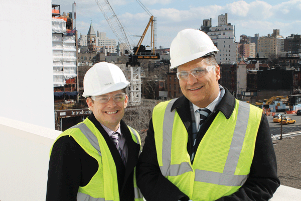 Dr. Eric Cruzen, emergency medical director, left, and John Gupta, executive director, of the Lenox Hill HealthPlex, on a balcony overlooking both the new Greenwich Lane residential project, left, and a future park and AIDS memorial site, right.  Photo by Lincoln Anderson