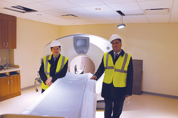 Dr. Eric Cruzen, left, and Executive Director John Gupta with a $1 million, low-dose, CAT-scan machine in the Lenox Hill HealthPlex E.D. “It can scan your entire body in two breaths,” Cruzen noted.  Photo by Lincoln Anderson