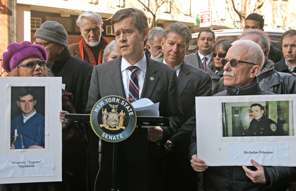 Flanked by community members holding photos of the slain auxiliary officers, state Senator Brad Hoylman introduced the Auxiliary Police Officers Yevgeniy Marshalik and Nicholas Pekearo Memorial Act.  Photos by Sam Spokony