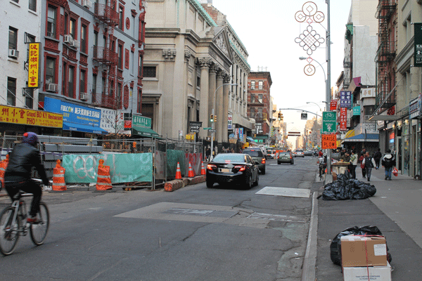 Despite some spots where materials are being stored in pens, such as at left, Grand St. in the Little Italy/Chinatown area is finally free of major street construction work. But resurfacing and curb replacement is up next, and eventually the bike lane markings will be painted in again, too.    PHOTO BY SCOOPY