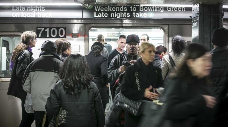Riders walk through a crowded Union Square subway station in Manhattan on March 20, 2014. 2013 set a 65 year record for transit ridership.