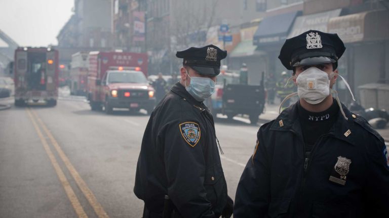East Harlem explosion 9 Police officers stand near the scene of an explosion and building collapse in East Harlem on Wednesday, March 12, 2014.