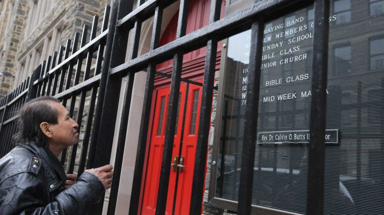 A passer by stops in front of The Abyssinian Baptist Church on 138th street in Harlem, Wednesday, April 2, 2014.
