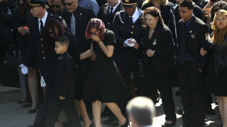 NYPD Officer Dennis Guerra remembered at memorial, funeral 27 Family members of fallen NYPD Officer Dennis Guerra watch as his coffin is carried into St. Rose of Lima Roman Catholic Church for his funeral Mass on Monday, April 14, 2014. Guerra, 38, died early Wednesday, April 9, of smoke inhalation and carbon monoxide poisoning after he and fellow officer Rosa Rodriguez were overcome by dense smoke and toxic fumes in a Coney Island high-rise fire on April 6.