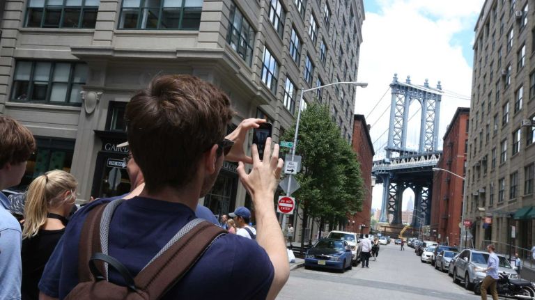 Visitors stop along Washington Street to photograph the Brooklyn Bridge in Dumbo on June 6, 2014.