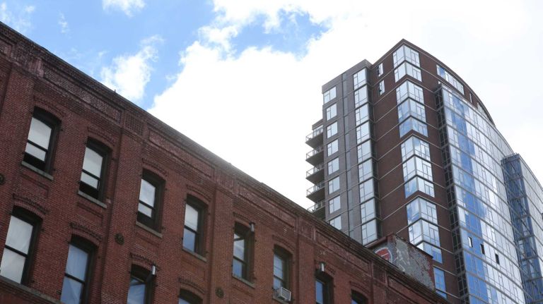 The glass apartment building of 100 Jay Street juxtaposed against an old warehouse in Dumbo on June 6, 2014.