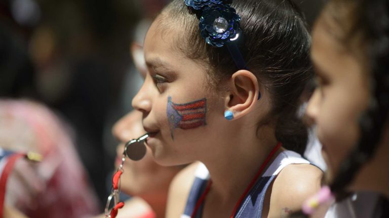 Manhattan resident JayLynn Villalonna, 7, center, blows a whistle during the 57th annual National Puerto Rican Day Parade in Manhattan on Sunday, June 8, 2014.