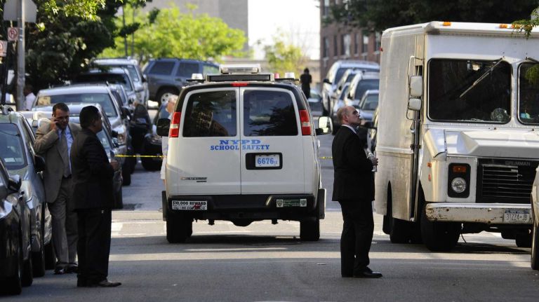 Police investigate the scene outside of IS 117 in the Bronx where Timothy Crump,14, was stabbed and killed after school on June 18, 2014.