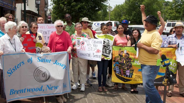 Immigration reform supporters hold signs during a press conference in Brentwood on June 4, 2014.