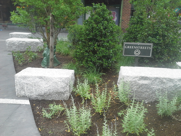 The redone Jane St. Triangle now sports granite blocks — set right into the soil  — intended only for brief seating, and lots of foliage.  Photo by Sergei Klebnikov