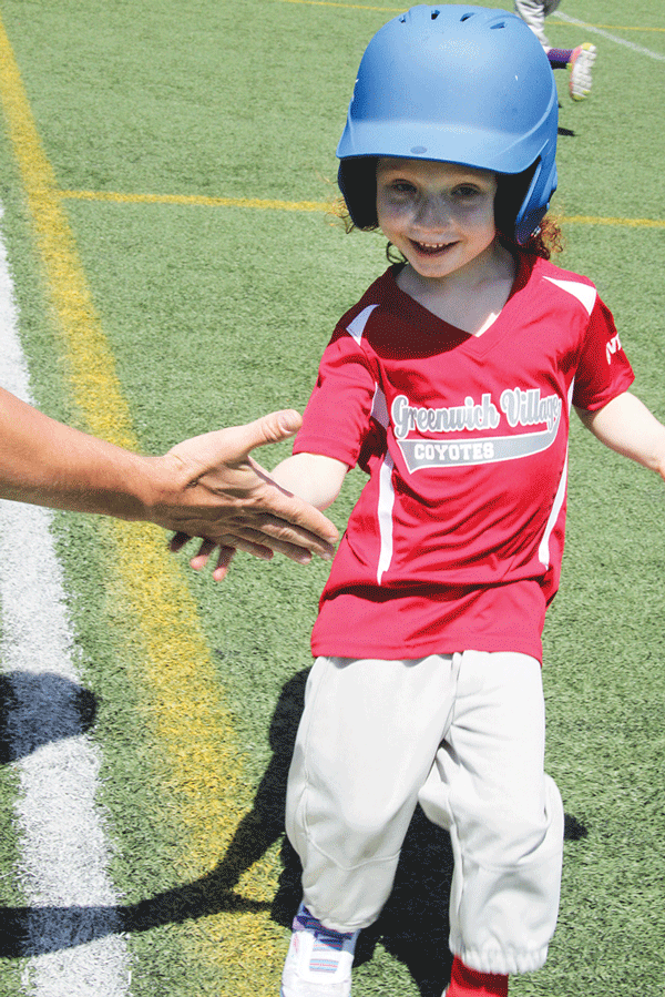 Give her a hand! She gets some encouragement from the first-base coach as she makes it safely down the line.