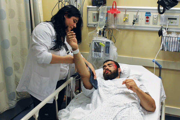 David Baez, 22, who had a bicycle accident, was the first patient at the Lenox Hill HealthPlex last Thursday morning. A doctor checked Baez’s condition after he received a CAT scan.   Photo by Lincoln Anderson