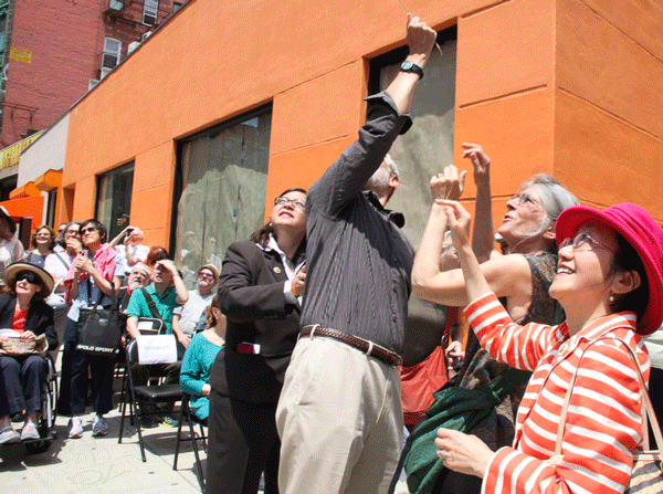 Yanking the string to pull off the paper wrapping covering the new Janet Freeman Way street co-naming sign.