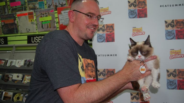 Bryan Bundesen, brother of owner Tabby Bundesen, picks up Grumpy Cat. 