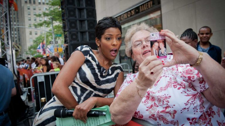 Today Show host Tamron Hall interacts with a fan as John Legend performs on the Today Show, Thursday, July 10, 2014.