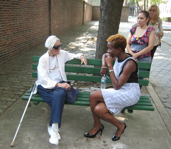 NYCHA Chairperson Shola Olatoye, front right, spoke with a resident, 92, in the First Houses back yard, as Brenda Santiago, the tenants council president, listened in.  Photos by Lesley Sussman