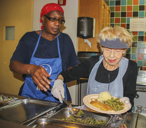 For three years, 92-year-old Chris Bennett, right, has worked with Loretta Wilson, left, the 20 Washington Square North senior center’s lunch-service supervisor. Bennett will be sorely missed when she moves to California soon to join her son.  Photo by Tequila Minsky