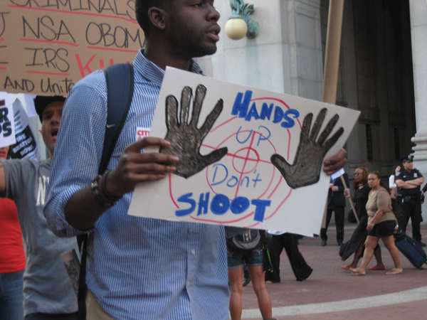 Photos by Dusica Sue Malesevic  A demonstrator’s sign references what witnesses say Michael Brown said, and did, before he was fatally shot by a Ferguson police officer. 