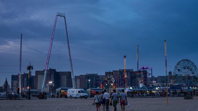 People walk on the beach in Coney Island Brooklyn, on August 1, 2014. By Anthony Lanzilote.