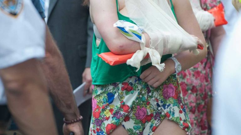 A woman, her arm bandaged and in a sling, was among at least 14 injured when two double-decker tour buses collided near Times Square, at West 47th Street and Seventh Avenue, on Tuesday, Aug. 5, 2014.