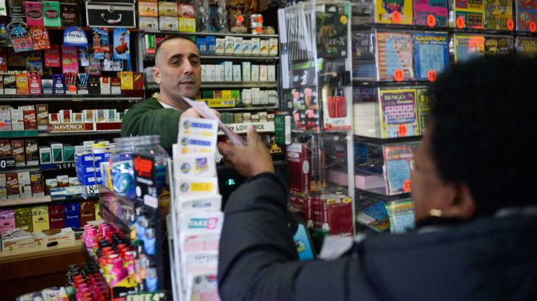 Mega Millions jackpot at $180 million Friday 2 Employee Ibrahim Guvecoglu hands over a Mega Millions ticket to a customer at the Mega Mart in North Amityville, Monday, March 17, 2014. The Mega Millions jackpot is up to 400 million dollars.