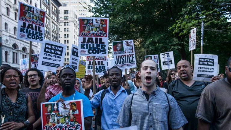 People protest outside City Hall in Manhattan against police brutality on August 18, 2014.  