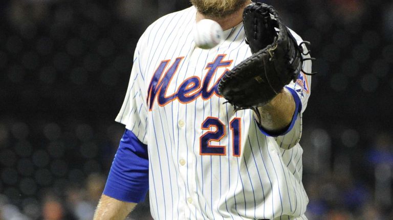 Mets Lucas Duda tosses a baseball to a fan between innings against the Washington Nationals in an MLB baseball game at Citi Field on Tuesday, August 12, 2014.