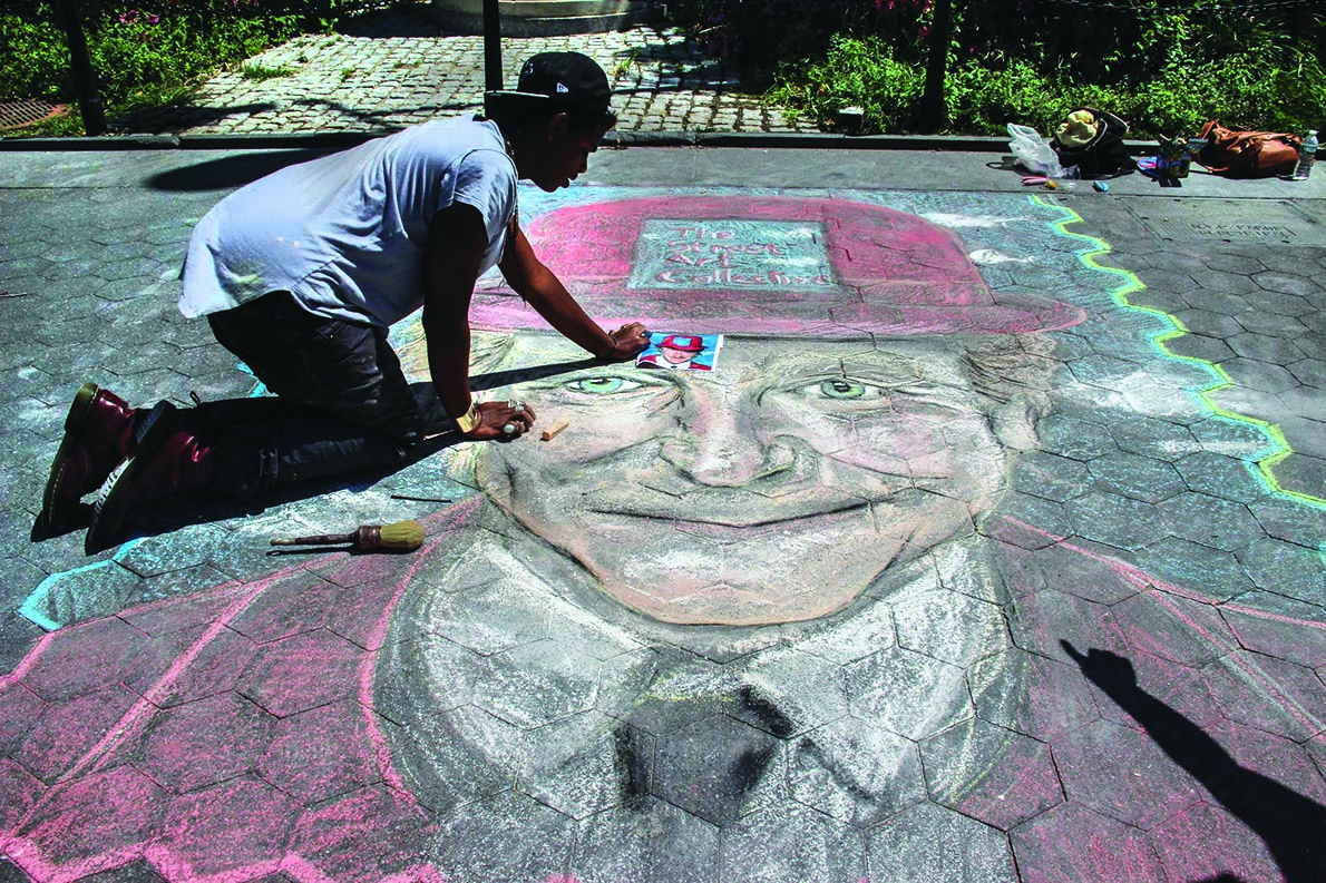 Members of The Street Artists Collective used an image from the Robin Williams movie “Toys” to create a chalk artwork of the late actor in Washington Square Park.  Photo by Tequila Minsky