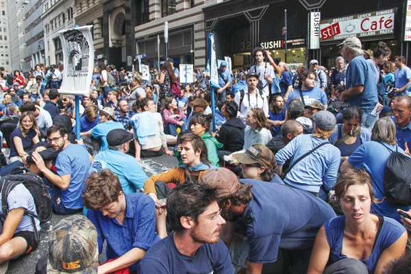 Blue shirt-wearing Occupy Wall Street activists held a Flood Wall Street action on Monday.  Photo by Tequila Minsky