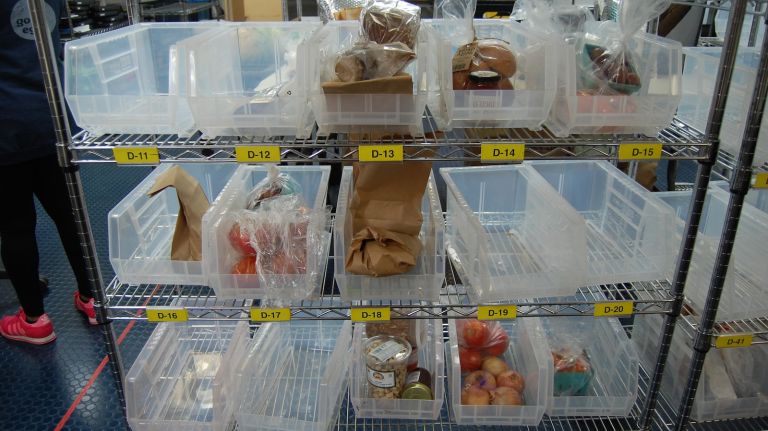 The packing of deliveries is streamlined, and extremely precise. Here, dry good items are in bins sorted by customer. It's 