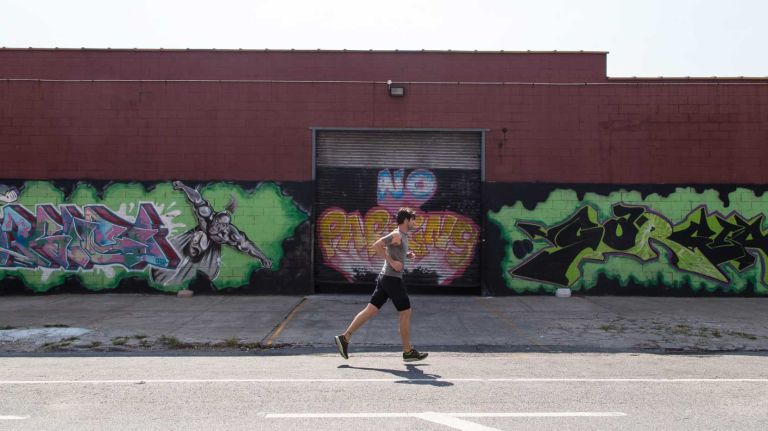 A jogger runs by street art on Banker Street and Meserole Avenue in Greenpoint.