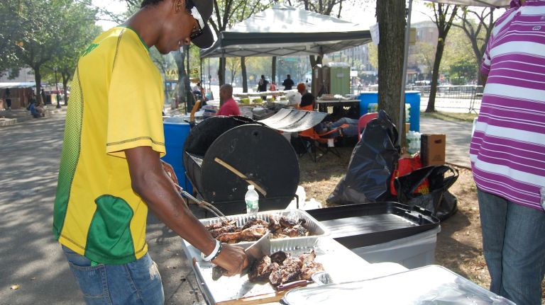 Jerk chicken getting chopped into parts for serving. 