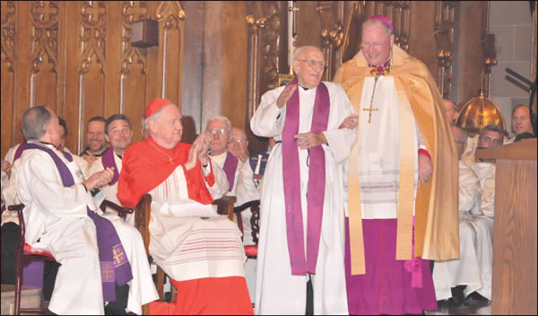 In December 2010, then-Archbishop Timothy Dolan helped longtime former St. Patrick’s Old Cathedral pastor Monsignor Nicola Marinacci, then 100, to his seat, as the cathedral was officially designated the Catholic Archdiocese’s basilica church. To the left of them, Edward Cardinal Egan applauded along with other clergy.   FILE PHOTO