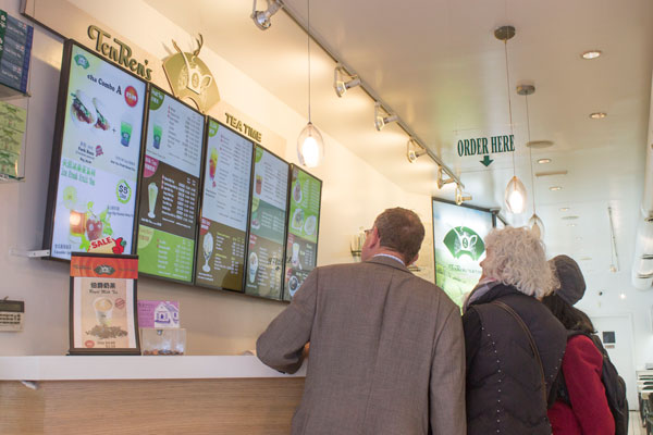 Customers check out the menu at Ten Ren’s Tea Time. 