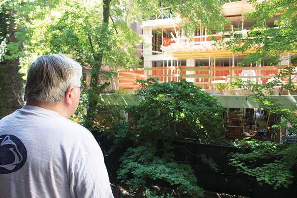 After-Hours Construction Still Rattling Residents 3 Photo by Zach Williams Little has changed since the summer regarding residents’ noise complaints. Here, in July, W. 15th St. resident Bill Butos observes the garden impacted by early morning construction on a 12-story building adjacent to his backyard.
