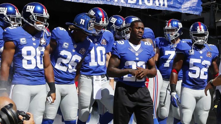 Former New York Giant David Wilson leads the team onto the field at MetLife Stadium on Sept. 14, 2014.