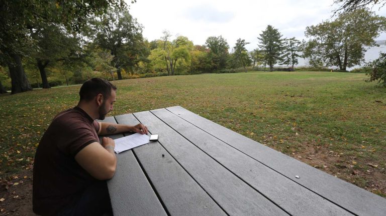 Mentor Ahmedi reads in Conference House Park in Tottenville.