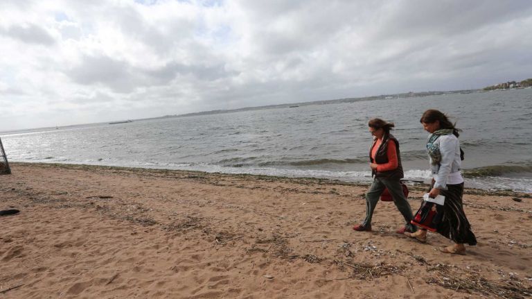 Visitors walk on the beach in Conference House Park.
