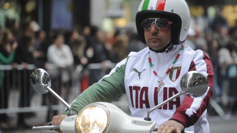 A partcipant in the Columbus Day Parade in Manhattan rides a Vespa scooter along the parade route on Fifth Ave. on Monday, Oct. 13, 2014. The parade is billed as the world's largest celebration of Italian-American heritage and culture.