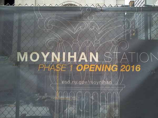 A Late Arrival, Yes, But Moynihan Station Construction Is On Track 3 Photos by Scott Stiffler Several mesh signs on Eighth Ave. announce the completion date of Phase 1, and allow passersby a view of the construction.