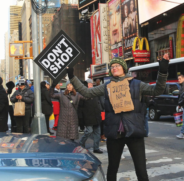 Holster your credit cards! On Black Friday, protesters angry over the lack of an indictment in the fatal police shooting of Michael Brown in Ferguson, Missouri, marched through Macy’s during the shopping frenzy, then up to Times Square chanting, “Hands Up, Don’t Shop!” Above, a woman blocked traffic in Times Square.   Photo by Jefferson Siegel