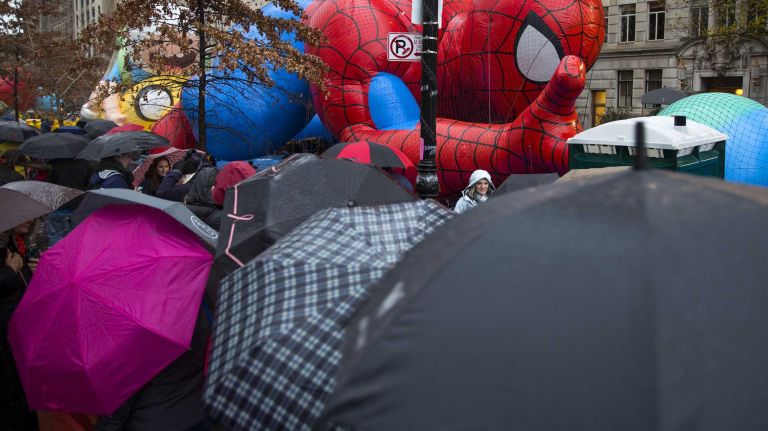 Macy's Thanksgiving Day Parade photos 16 People with umbrellas cram together to get a view as the Macy's Thanksgiving Day Parade balloons are prepared and inflated by the Natural History Museum near the parade route Wednesday, Nov. 26, 2014, in preparation for the decades old tradition of the Thanksgiving Day parade Thursday.