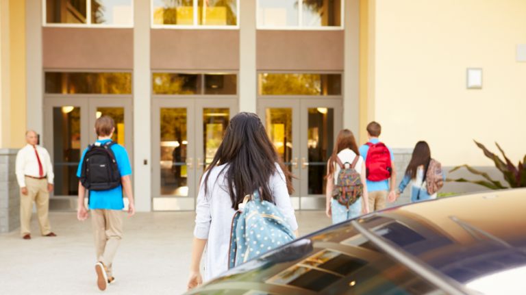 High school students being dropped off at school.