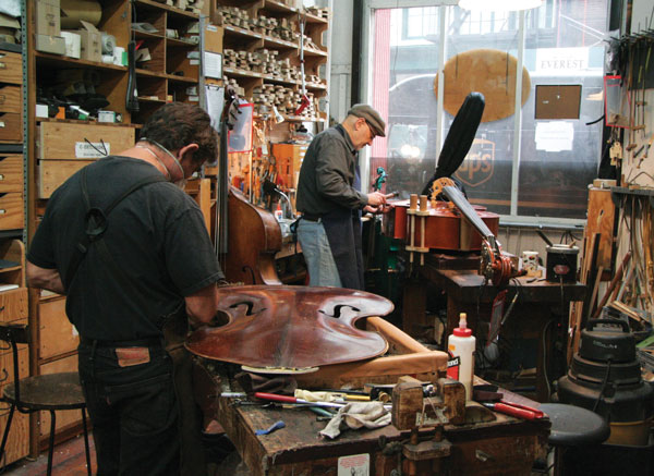 Downtown Express photos by Ellen Mandel  David Gage, right, owns the bass repair shop. Above, Sprocket Royer, left, and Mike Weatherly hard at work.