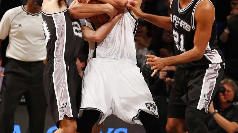 Brook Lopez of the Brooklyn Nets fights to keep control of a rebound late in the fourth quarter against Manu Ginobili and Tim Duncan of the San Antonio Spurs at Barclays Center on Wednesday, Dec. 3, 2014.