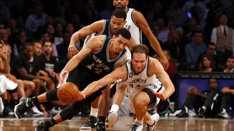 Bojan Bogdanovic of the Brooklyn Nets battles for a loose ball against Danny Green and Cory Joseph of the San Antonio Spurs during an NBA game at Barclays Center on Wednesday, Dec. 3, 2014.