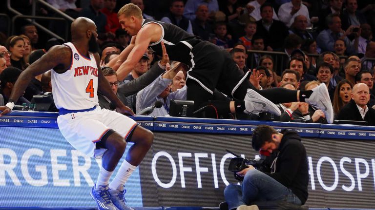 Knicks vs. Nets 28 Mason Plumlee of the Brooklyn Nets dives into the crowd trying to save a ball past Quincy Acy of the New York Knicks at Madison Square Garden on Tuesday, Dec. 2, 2014.