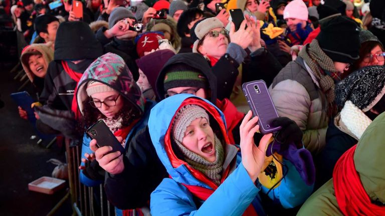 Annette Hughes of Idaho (blue hood) taks a photo while celebrating New Years Eve in Time square NY on December 31, 2014.